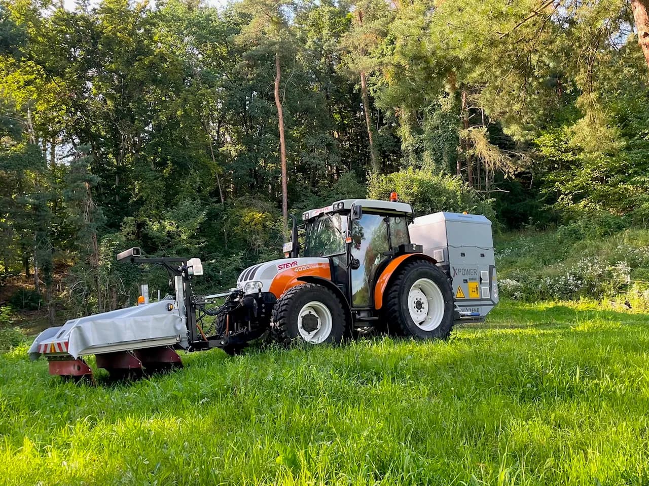 Traktor mit heckmontiertem XPower-Gerät im Grünflächeneinsatz
